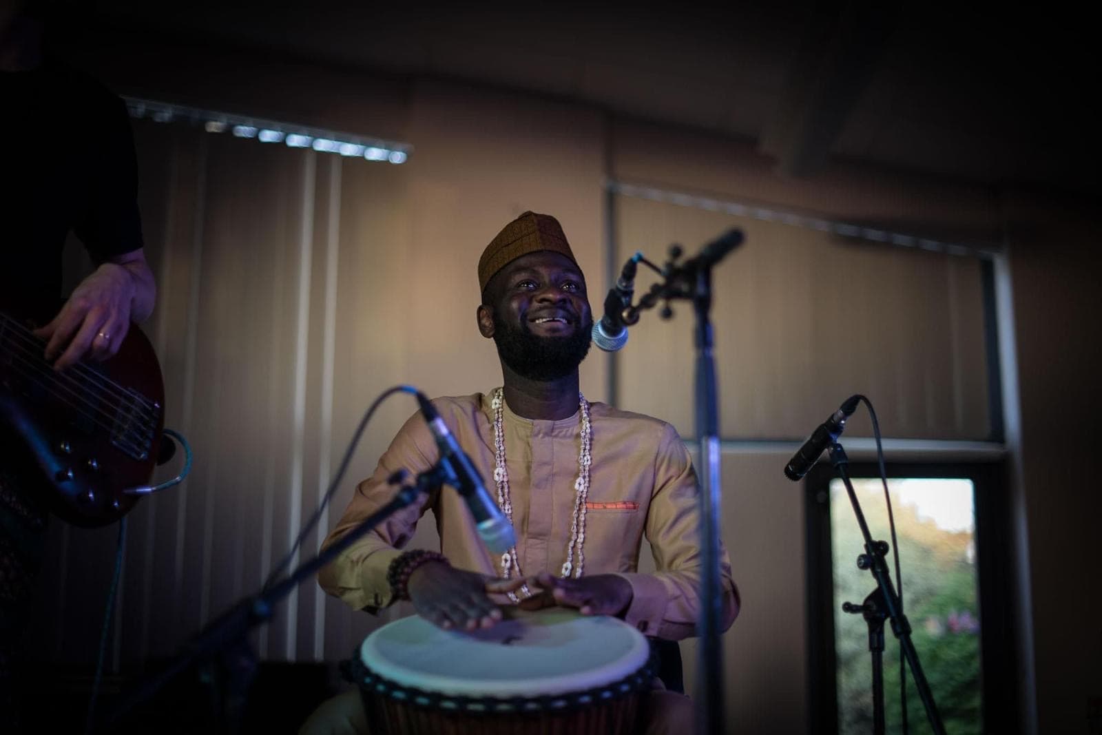 AfroSync percussionist playing the djembe in traditional dress